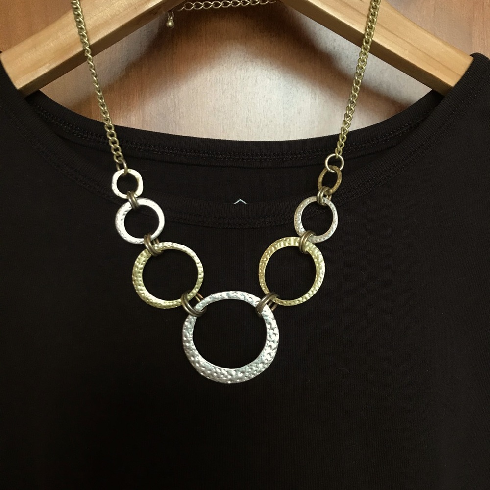 Open circle necklace with hammered texture. Gold and silver toned